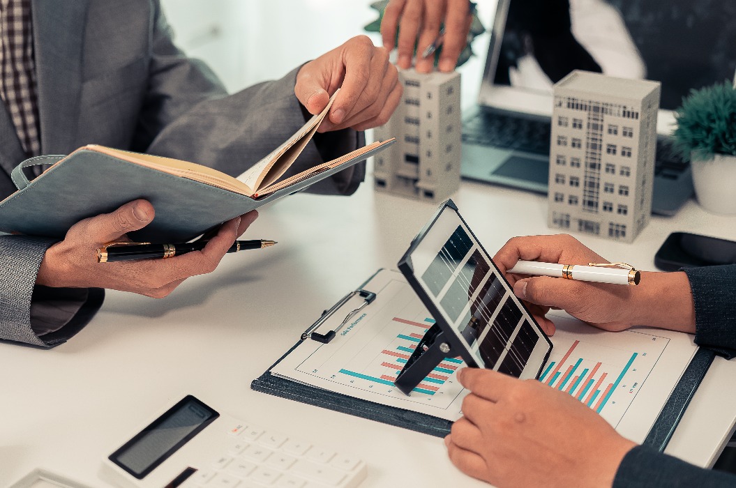 Alternatives Energiekonzept, Elektroingenieur und Geschäftsmann diskutieren über ein neues Projekt zur Installation von Sonnenkollektoren auf dem Dach eines Gebäudes. Bilder in Nahaufnahme